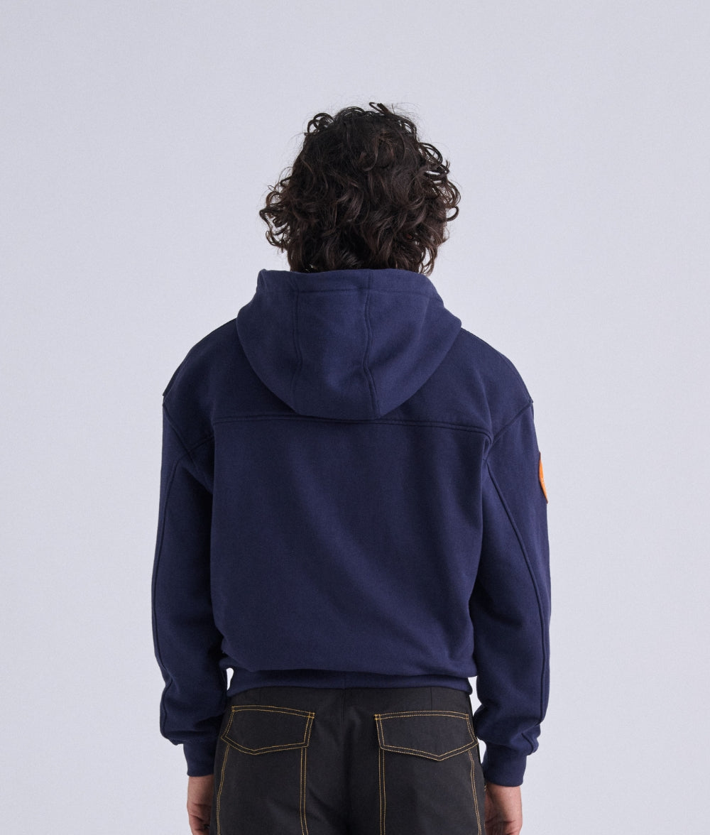 Man  wearing Rebolf Swing or Freeze Navy blue hoodie with a patch on the right shoulder 